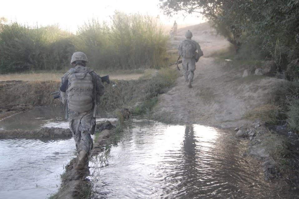 Service members moving through a water crossing