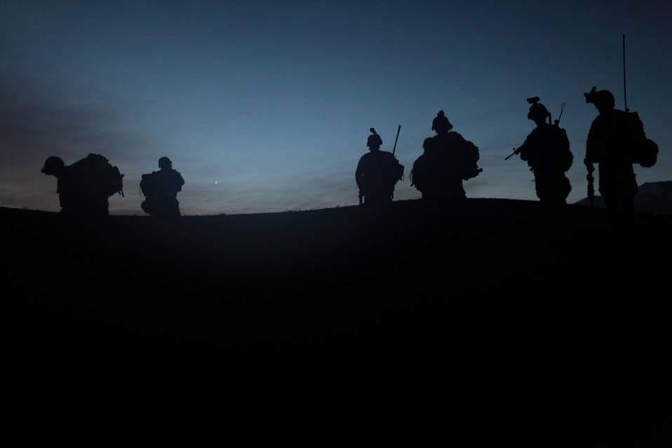 Service members silhouetted at dusk